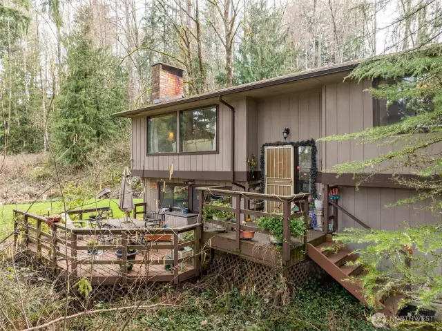 Front entry, stairs and deck. This looks out over what soon will burst forth in lush green leaves that bring beauty and privacy.