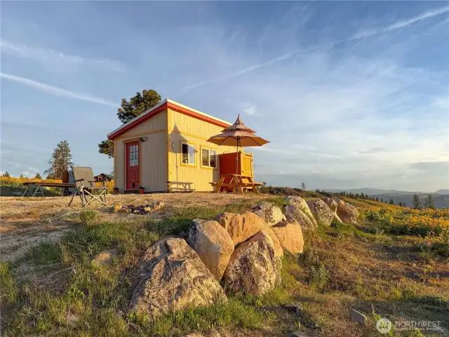 Cabin sits on a raised pad with rock wall