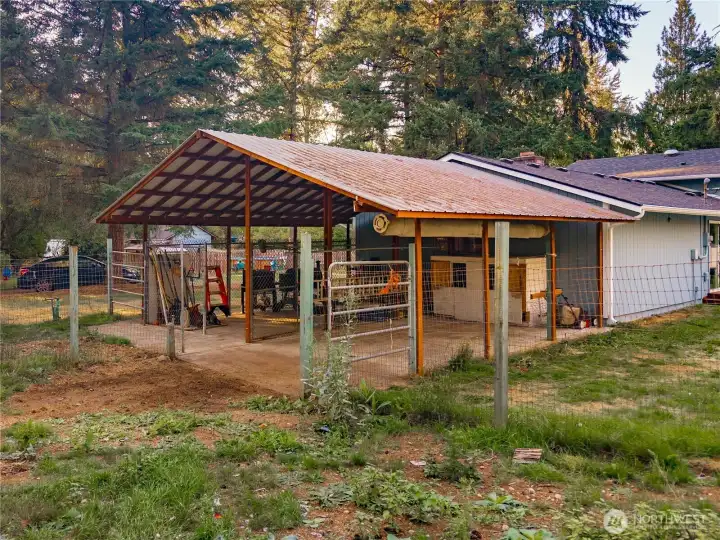 Fenced enclosure with concrete pad and roof