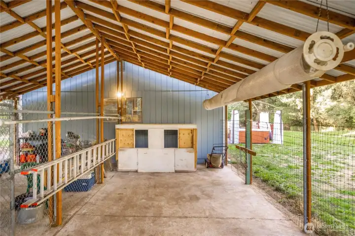 The dog kennel is versatile and has its own optional door to enter the garage. On the right is a pool bubble cover on a roller