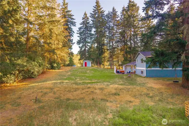 The property has a second driveway and is lined with privacy trees