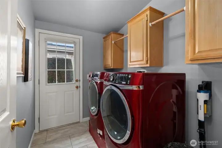 Spacious utility room with cabinetry, and outdoor access.