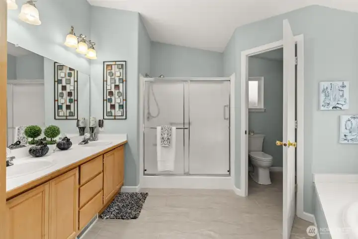 Ensuite with dual vanities, step-in shower, and soaking tub.