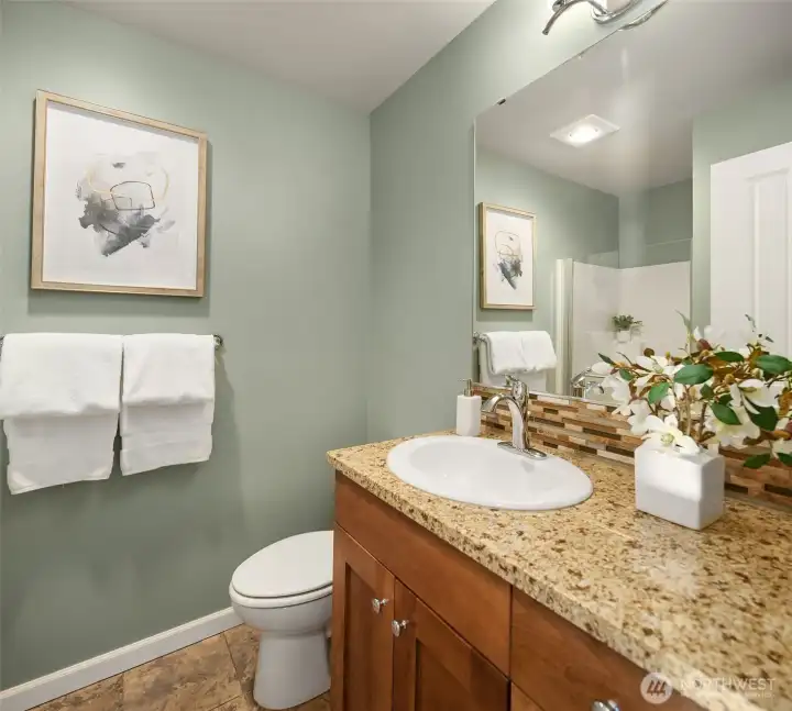 Main floor bathroom with shower, across the hall from another bedroom or office.