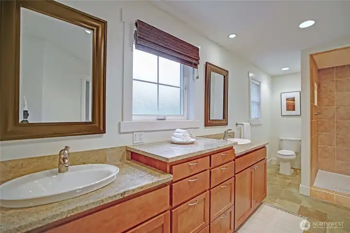 Tiled walk-in-shower w/ double shower heads.