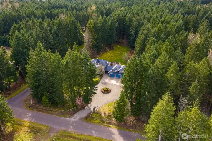 Overhead view facing southwest, showcasing entryway and private forest in back of the home.