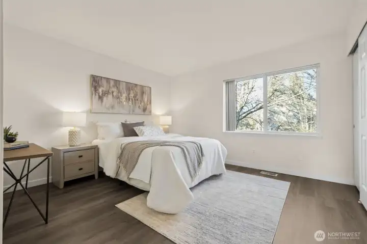 The primary suite features large closets and an attached three-quarter bath with updated finishes, including a new mirror, updated cabinet, tile countertop sink, and faucet. From here, enjoy tranquil views overlooking the backyard area, adding a sense of calm to your daily routine.