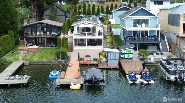 Outdoor living at the lake. Over the water bar, a boat lift and a floating jet ski dock also stays.