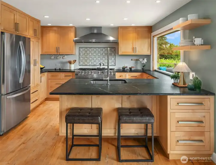A newly remodeled kitchen boasts a BlueStar range, Best vent hood, soapstone counters and lovely wood finishes.