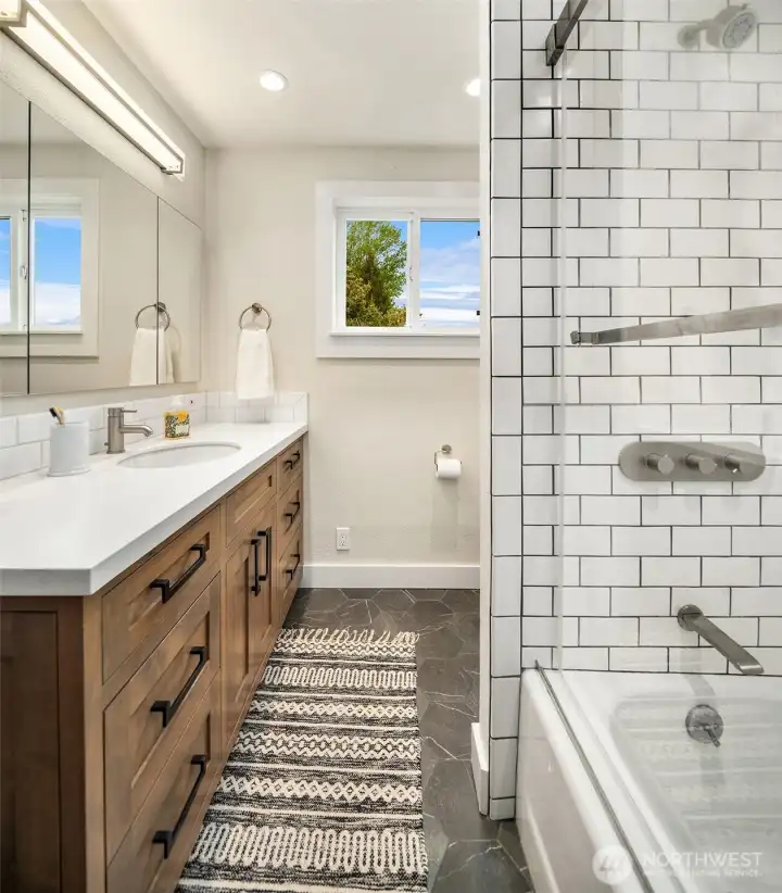 The thoughtfully updated main level bathroom hosts a tile shower/tub combo, new vanity, and a Toto commode.