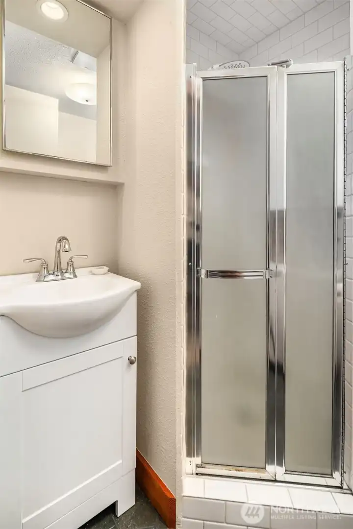 The lower level 3/4 bathroom sits between the office and laundry room.