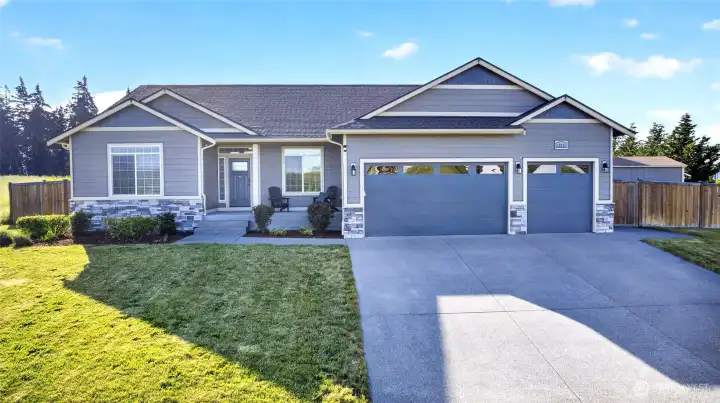 Inviting curb appeal with covered front porch, modern finishes, and plenty of parking space for guests and everyday living.