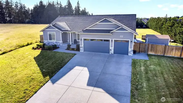 Expansive homesite with additional side-yard access, generous driveway space, and a peaceful setting.