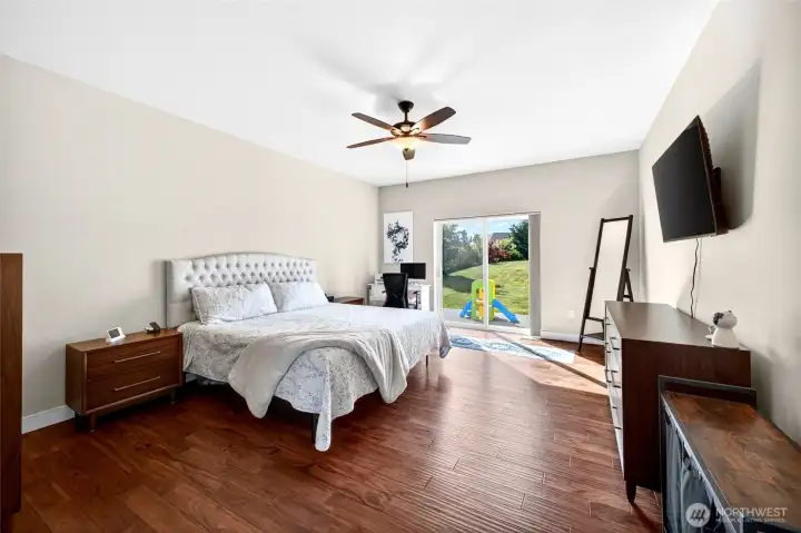 Bright and airy primary retreat with direct patio access and peaceful backyard views.
