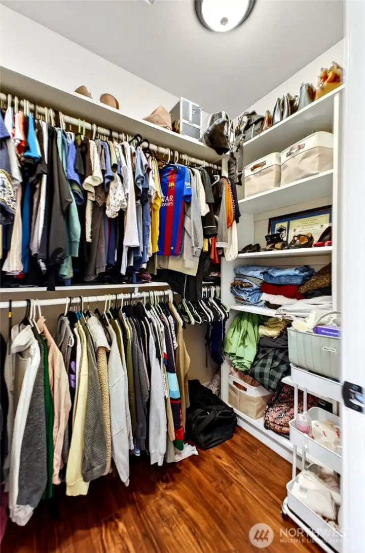 Large primary walk-in closet with extensive hanging space, shelving, and organized storage throughout.