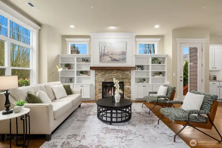 The inviting living room is a showstopper, featuring vaulted ceilings, oversized windows flooding the space with natural light, a cozy gas fireplace, and elegant custom built-ins — a perfect blend of comfort and sophistication. The inviting living room is a showstopper, featuring vaulted ceilings, oversized windows flooding the space with natural light, a cozy gas fireplace, and elegant custom built-ins — a perfect blend of comfort and sophistication.