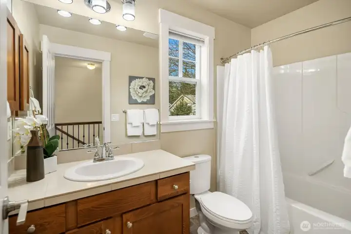 The full secondary bath features a shower/tub combo, warm wood vanity, and classic finishes — a clean and well-appointed space serving the upper level bedrooms with ease. The full secondary bath features a shower/tub combo, warm wood vanity, and classic finishes — a clean and well-appointed space serving the upper level bedrooms with ease.