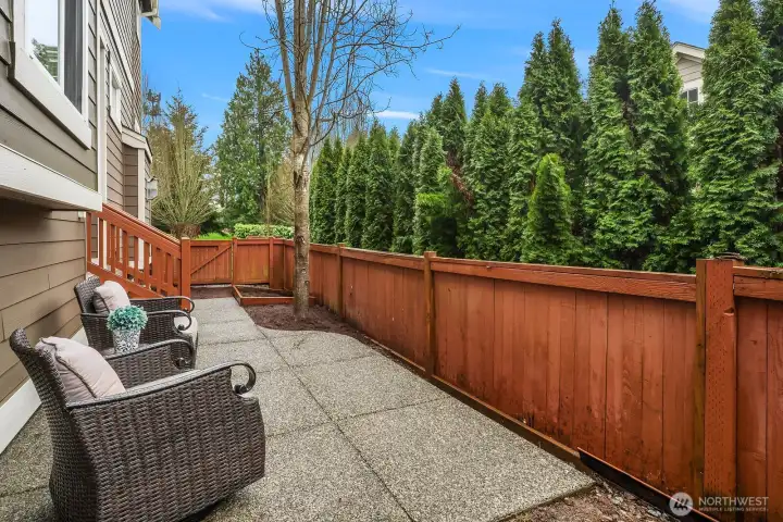 Another view of the private patio showcases the fully fenced yard and lush evergreen backdrop — a serene and secluded outdoor space perfect for entertaining, relaxing, or simply enjoying the natural beauty of the surrounding landscape. Another view of the private patio showcases the fully fenced yard and lush evergreen backdrop — a serene and secluded outdoor space perfect for entertaining, relaxing, or simply enjoying the natural beauty of the surrounding landscape.