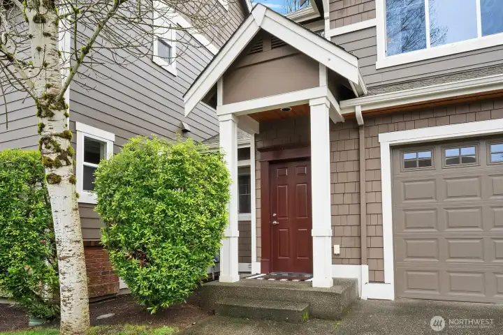 The welcoming front entry features a classic covered portico, warm wood door, and lush surrounding greenery — a charming and polished first impression that sets the tone for the quality found throughout this exceptional home. The welcoming front entry features a classic covered portico, warm wood door, and lush surrounding greenery — a charming and polished first impression that sets the tone for the quality found throughout this exceptional home.