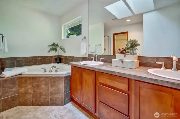 Tranquil primary bathroom offers double stink, large soaking tub, walk in shower with new glass doors and xtra large walk in closet Tranquil primary bathroom offers double stink, large soaking tub, walk in shower with new glass doors and xtra large walk in closet