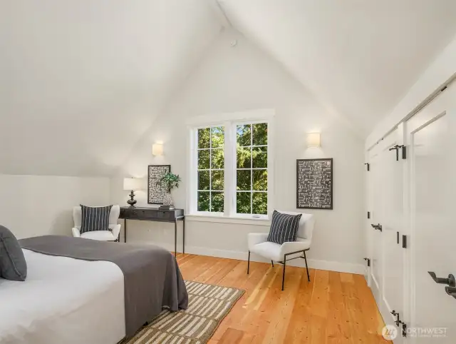 One of two vaulted ceiling bedroom spaces upstairs. This overlooks the gardens and woodland beyond. Large walk in closets with exceptional storage.