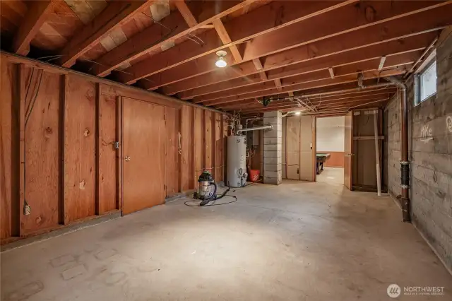 Unfinished basement room with hot water heater and furnace.
