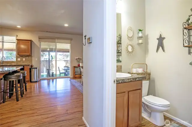 From the hallway, enjoy a clear view into the kitchen and dining spaces. The powder room is located just to the right.