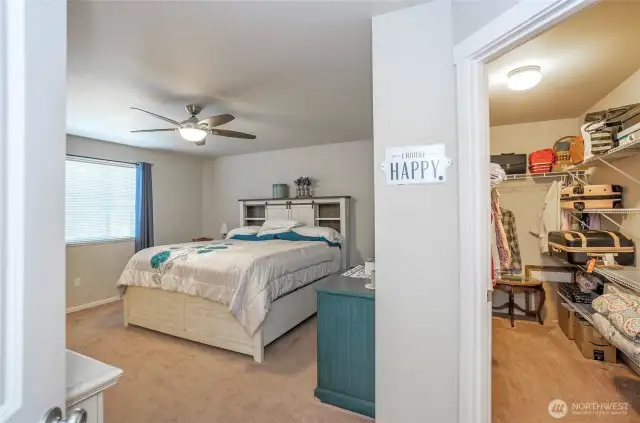 The primary suite boasts a walk-in closet to the right, complete with extra shelving for ample storage space.
