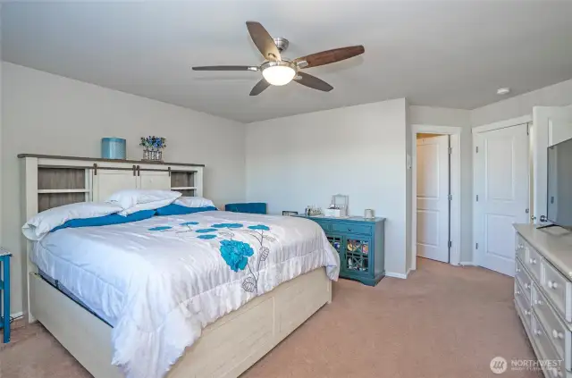 This view of the primary suite showcases the elegant ceiling fan, adding both comfort and style.