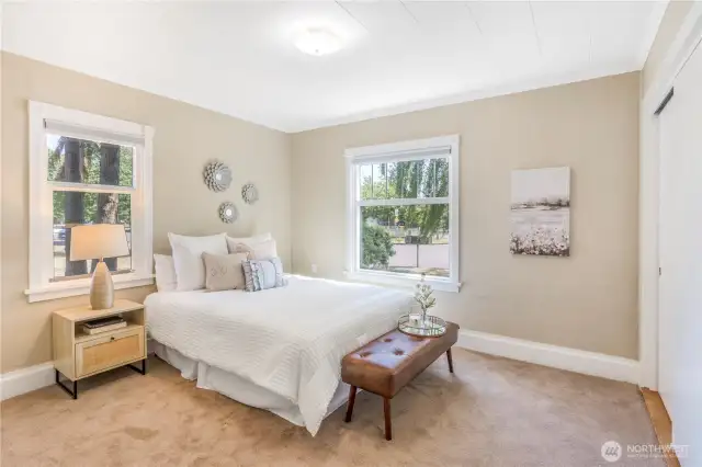 Primary bedroom has tons of natural light from big windows.
