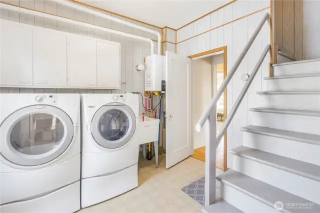 Huge laundry room with great storage and steps that lead to upstairs.