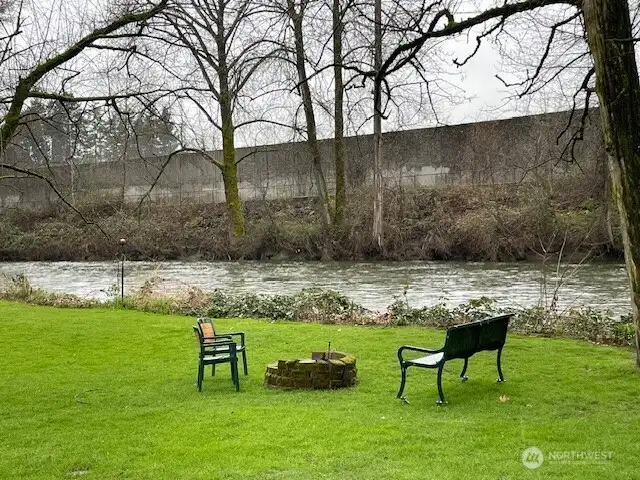 Residents enjoy the back yard firepit on the river's edge.