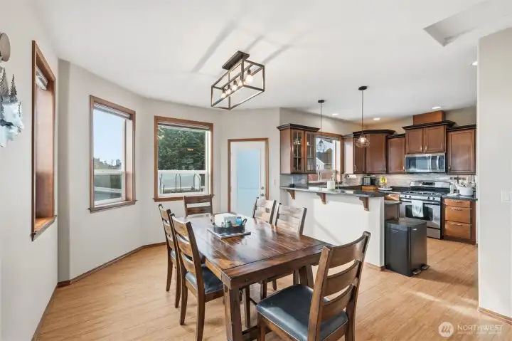 Bright and spacious dining room open to the kitchen. That door leads to the back deck and covered patio.