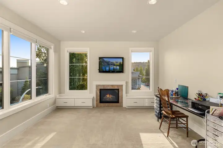 Gas fireplace in the sitting area of the primary suite with great lake views