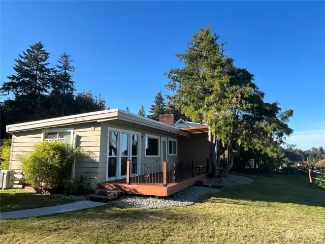 Front of the house on a sunny day.  Cozy deck.