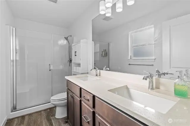 Private bath with dual sink vanity and a large step-in shower, off the primary bedroom.