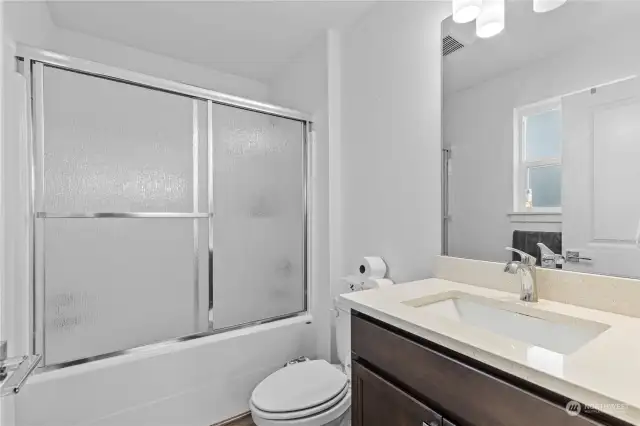 Private bath with a tub/shower combo off the primary bedroom.