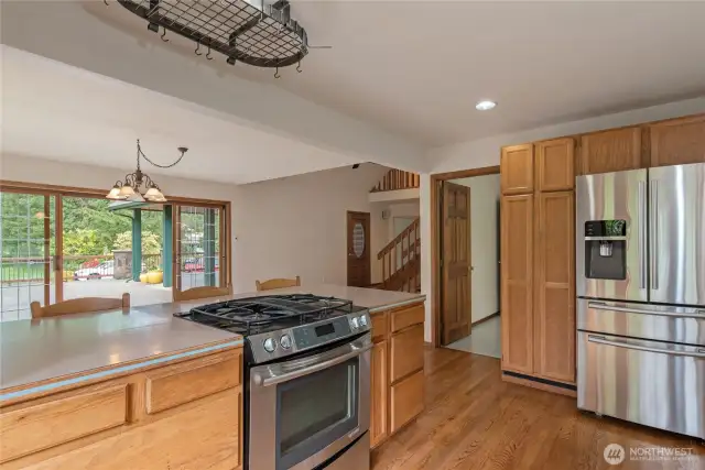 Kitchen looks over dining space and out to patio.
