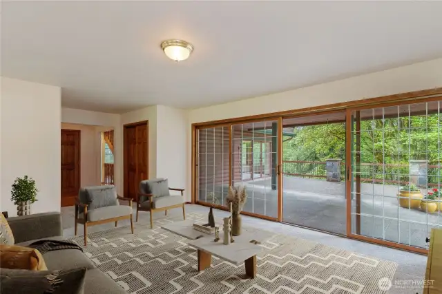 Virtual Staged Living room looking out to covered patio and to the forest. Very private setting.