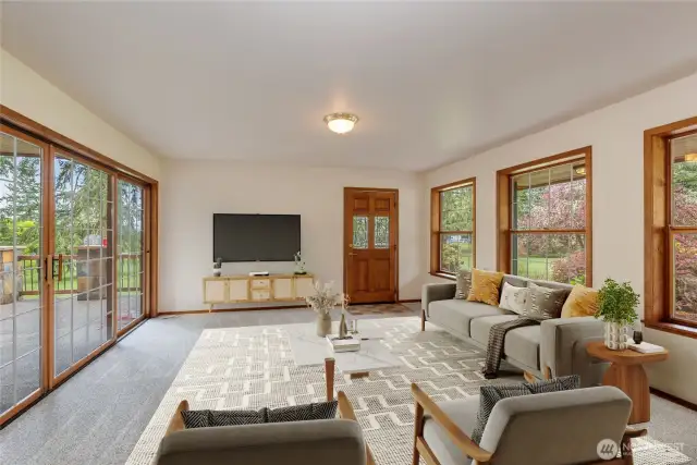 Virtual Staged Living room with sliding doors to deck.  Surrounded by windows to enjoy the lovely surroundings.