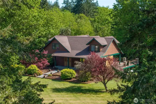 Front of home.  Spacious manicured lawn around two sides of home is level.