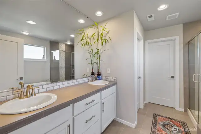 Double sinks with tile countertops & soft close drawers & cabinets.