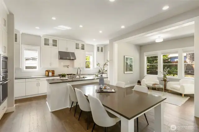 Anchoring the home with style and function, this modern kitchen boasts an oversized island with seating, quartz countertops, and a professional-grade range with a statement hood. Bathed in natural light and open to a charming sitting area, it’s perfectly designed for both daily living and elegant entertaining.