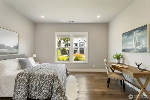 Located on the main level, this spacious guest bedroom offers a peaceful retreat with large windows, hardwood floors, and plenty of natural light. Whether used for visitors or as a private home office, the flexible layout provides comfort and quiet versatility.