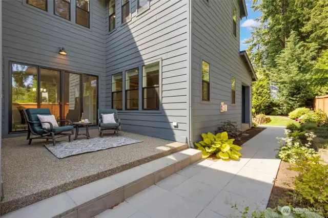 This inviting side yard features a charming patio just off the dining room—an ideal spot for quiet morning coffee or evening conversation. Surrounded by lush landscaping and easy-care pathways, it’s a private extension of the home’s indoor-outdoor lifestyle.