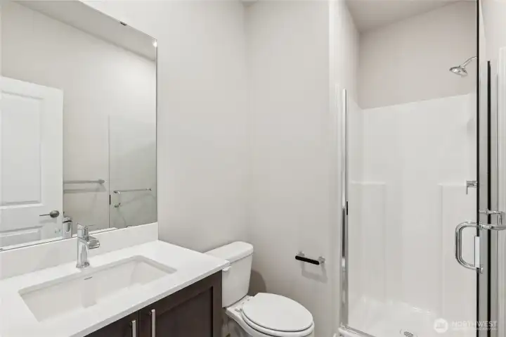 Lower level bathroom has a walk-in shower. Photo is representational. Actual home is under construction and finishes and colors will vary. See site agent for details.