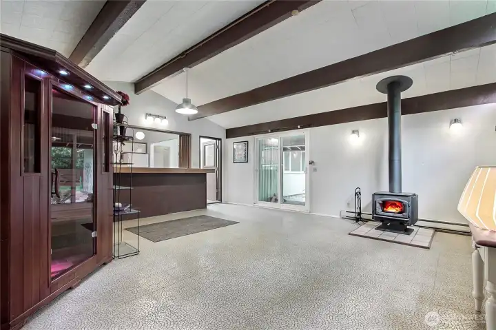The family/rec room with eating bar adjoins the kitchen and a free-standing woodstove provides warmth in the winter. The sliding glass doors give easy access to the outdoors.