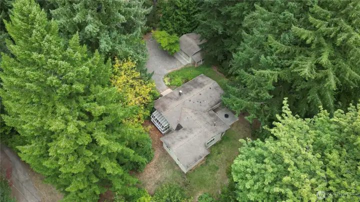 This aerial view shows the sprawling home with attached greenhouse and detached double-car garage.