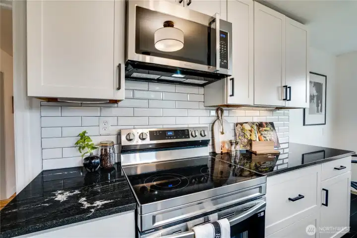 Brand-new stainless steel electric range with smooth-top cooktop, over-the-range microwave with built-in vent.