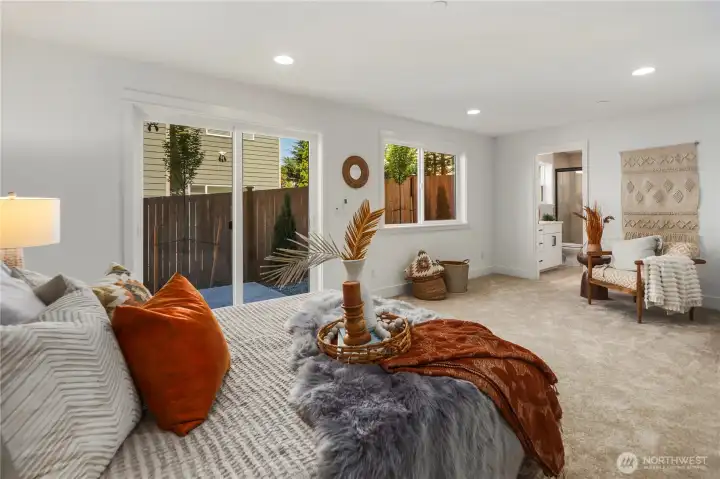 Lower Level Suite: Expansive lower-level suite features plush carpeting, sliding glass doors to the backyard, and large windows that fill the room with natural light. This versatile retreat works beautifully as a private guest suite, multi-generational space, or flexible bonus room. Staged photos are of the model home of the same floorplan within the Foxmoore community and are for visualization purposes only. Colors, finishes, and layout can and will vary.